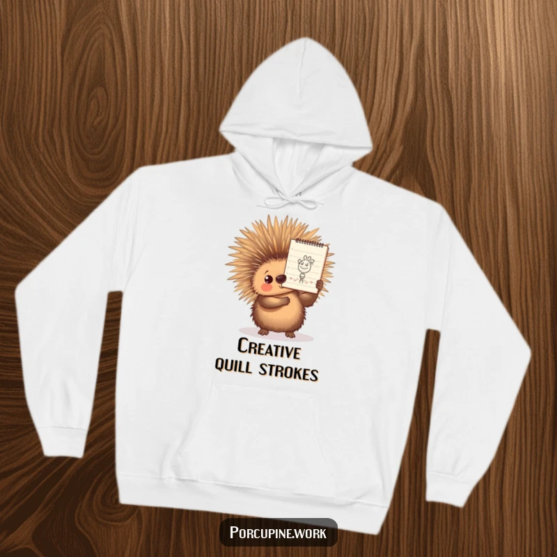 Funny Hoodie showing a porcupine proudly holding a notepad with a small, intricate doodle, symbolizing artistic accomplishment and warm humor.