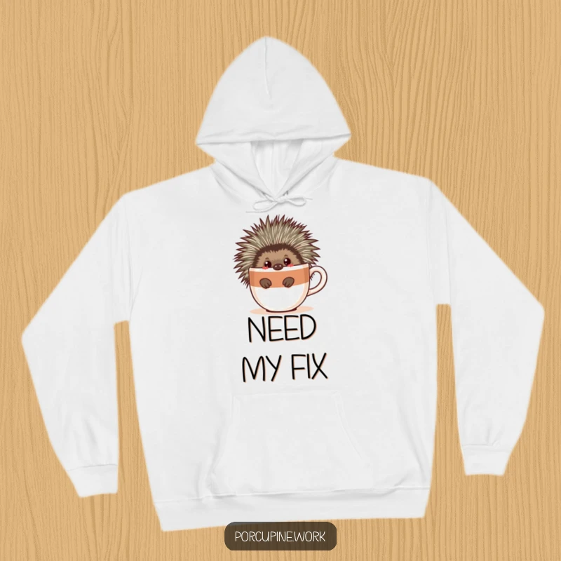 Funny hoodie featuring a porcupine peeking from behind a large coffee cup, embodying a cozy, caffeinated, and humorous vibe.