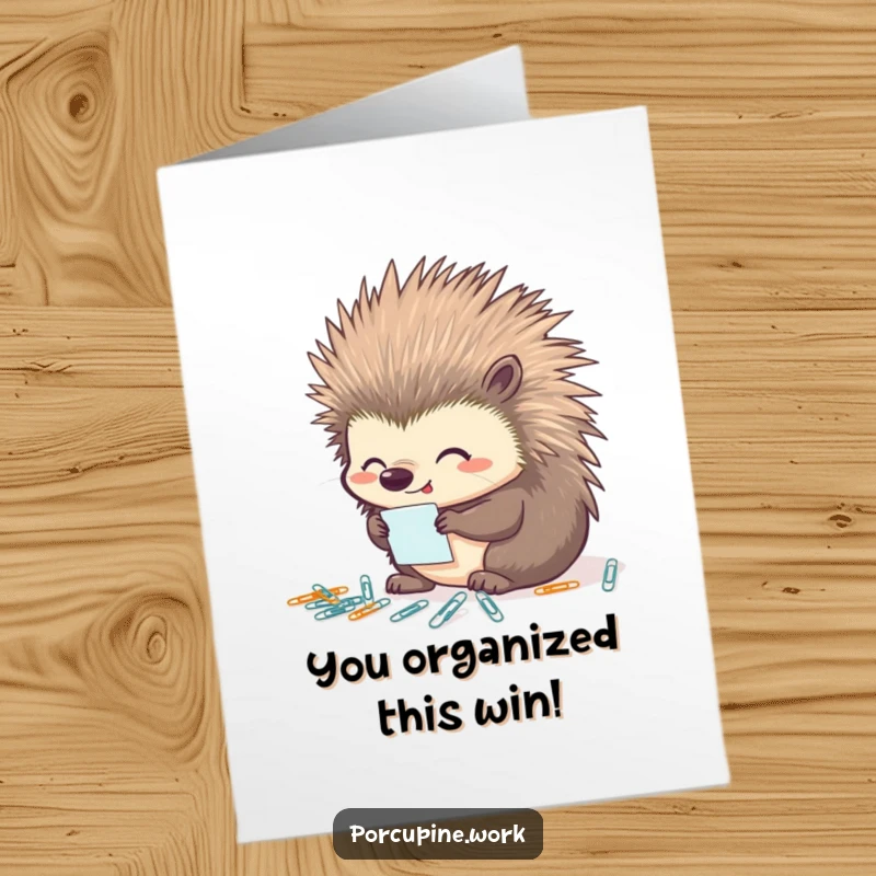 Funny Free Printable Congrats Card: A porcupine smiles proudly while meticulously arranging small paperclips.